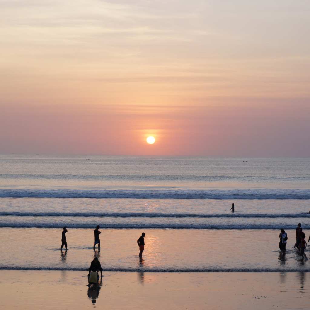 people enjoy sunset in kuta beach