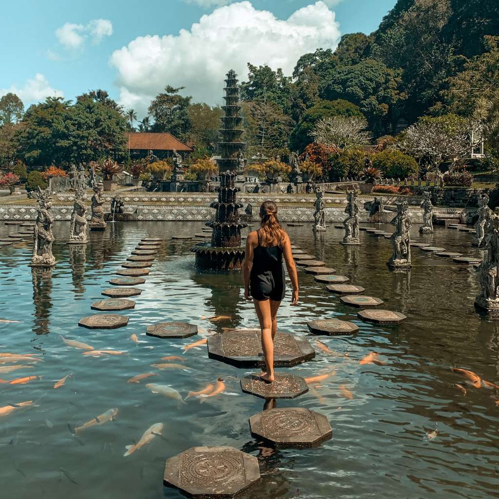 A girl is enjoy exploring Tirta Gangga Bali